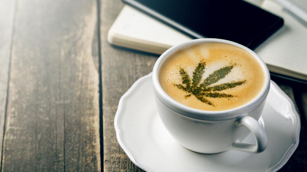 Cup of coffee with weed leaf on its surface